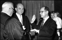 Frederick Gary Dutton is sworn in as assistant secretary of state for congressional relations by Chief Justice Earl Warren. Secretary of State Dean Rusk as June and Eve Dutton witnessed the Dec. 5, 1961, oath taking. (Associated Press) 